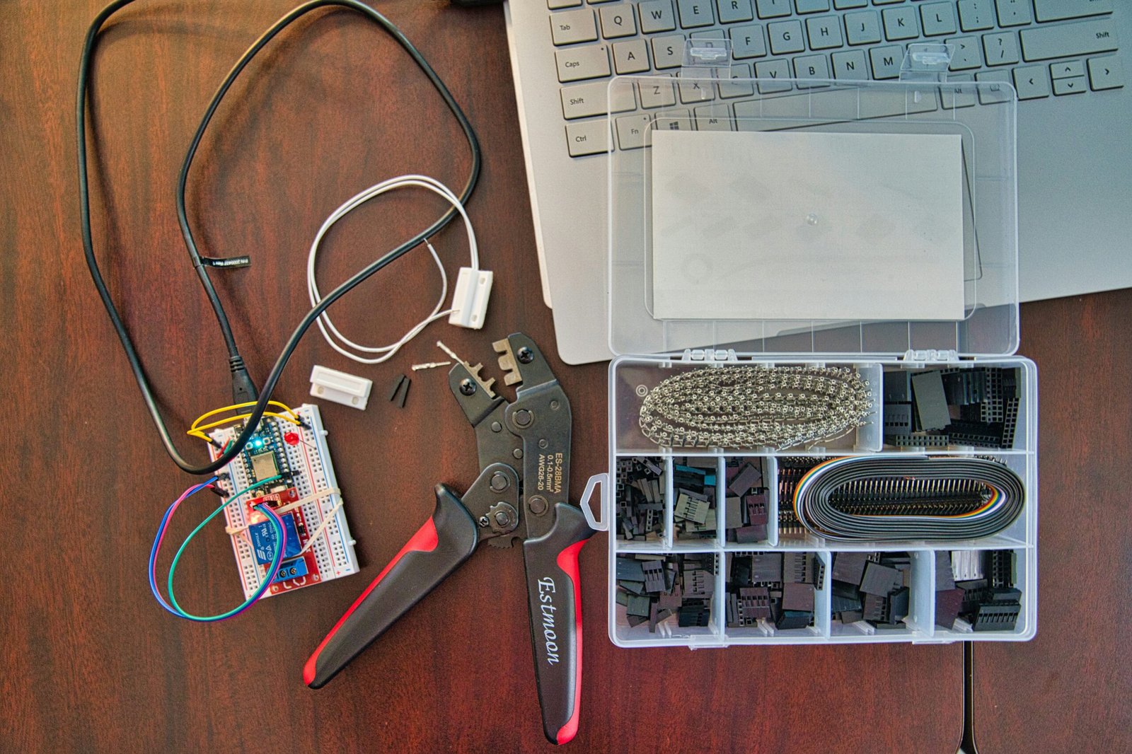 red and silver scissors beside white laptop computer